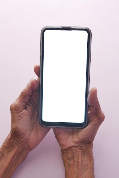 Mano delle donne anziane che tiene uno smartphone con schermo bianco