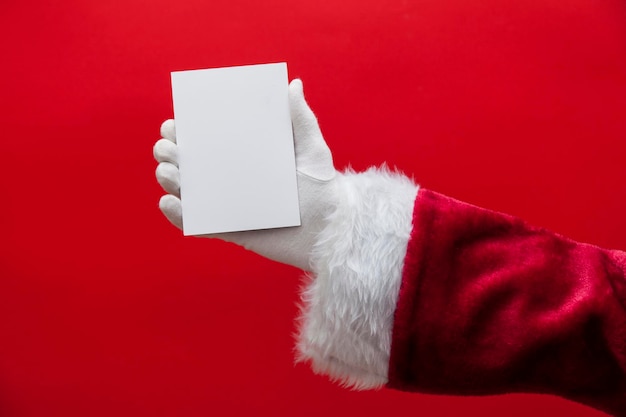 Mano di Babbo Natale che tiene un segno bianco in bianco