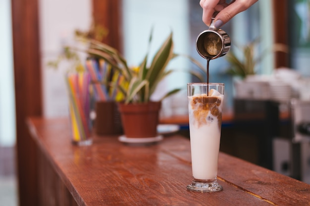 Mano di barista che fa latte versando latte o cappuccino