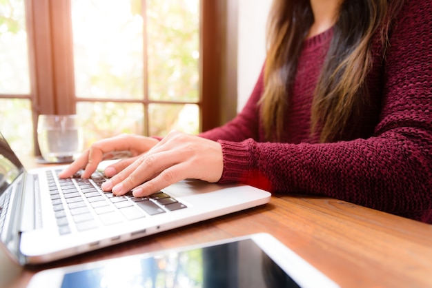 Mano di donna che lavora sul suo computer portatile. Concetto di tecnologia di social networking.