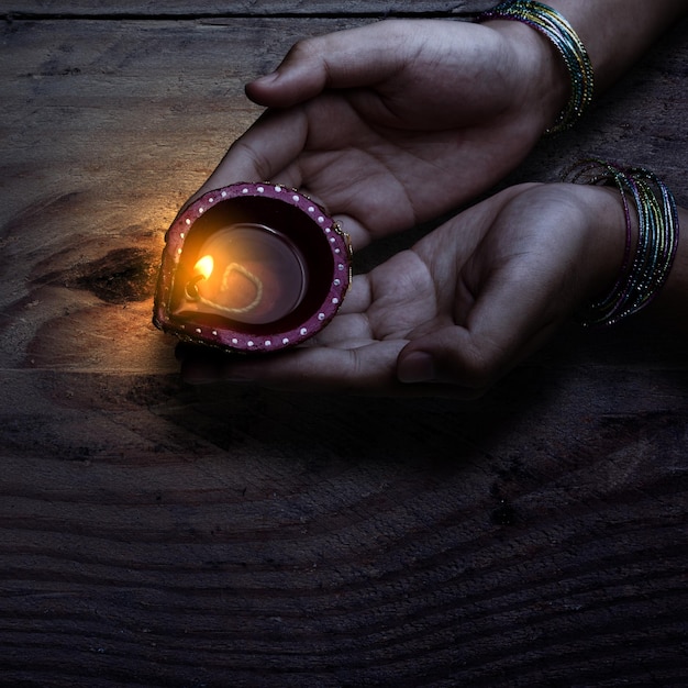 Mano di donna che tiene lampade a olio Diya per il festival Diwali Festival di Diwali La celebrazione del Festival indù delle luci