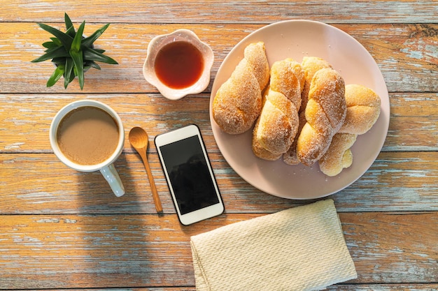 Mano di donna che utilizza uno smartphone vuoto durante la colazione