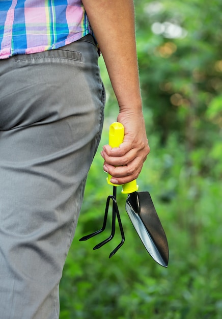 Mano di donna con attrezzo da giardino