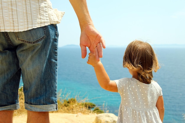 Mano di genitore e figlio vicino al mare