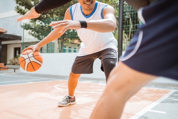 Mano di giocatori di basket che trasportano una palla con una tecnica di dribbling alta