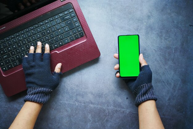 Mano di hacker che ruba dati dallo smartphone