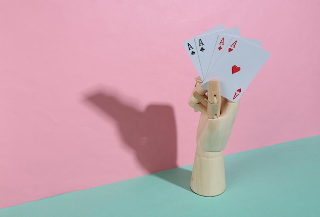 Mano di legno che tiene quattro assi su sfondo blu pastello rosa Ombra alla moda Concept art Minimalismo Layout creativo