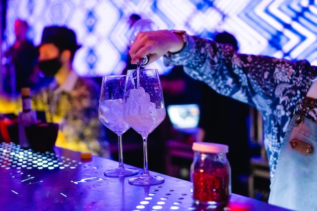 Mano di un barista che serve cocktail in un bar della discoteca