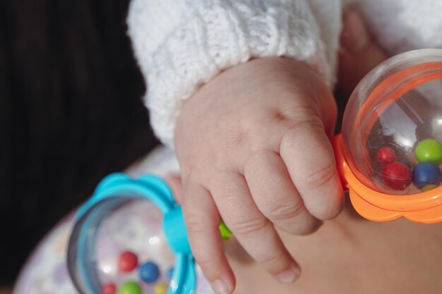 Mano di un neonato con un giocattolo. Giocattolo di plastica per un bambino