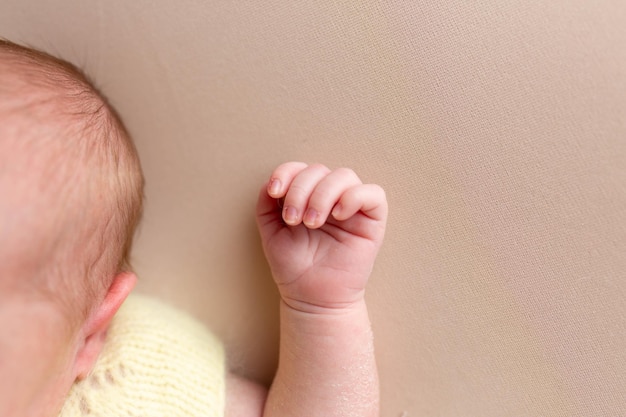 mano di un neonato. piccole penne. mani su sfondo bianco