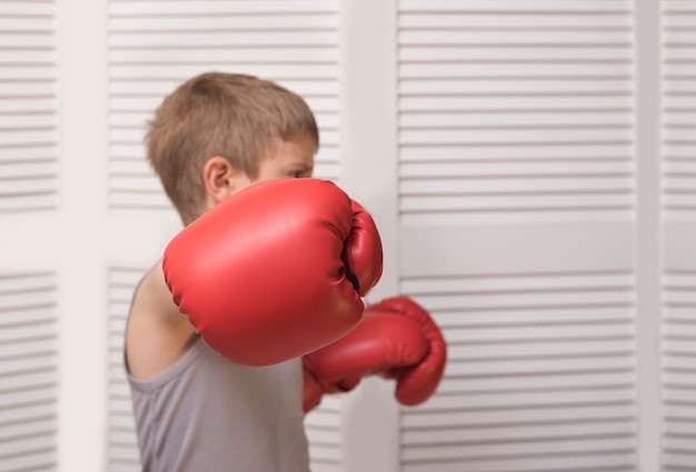 Mano di un ragazzo in un guantone da boxe rosso.