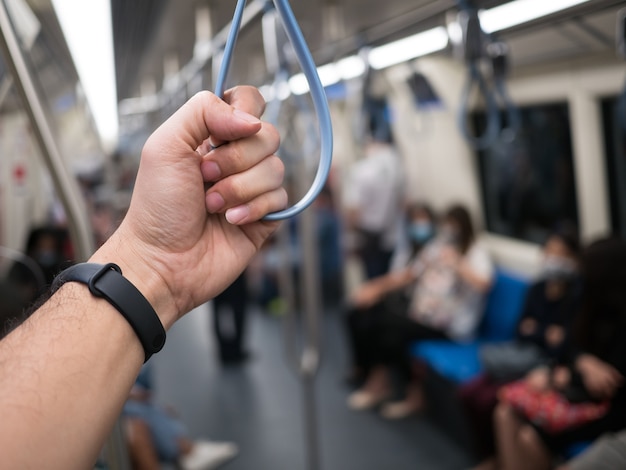 Mano di un uomo che tiene la maniglia nella metropolitana