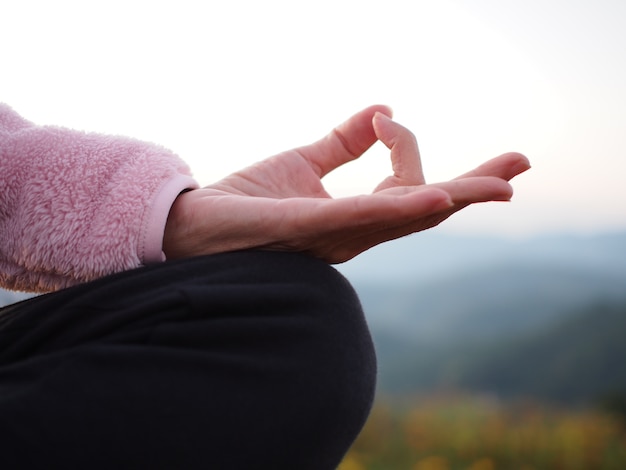 mano di una donna che medita in uno yoga