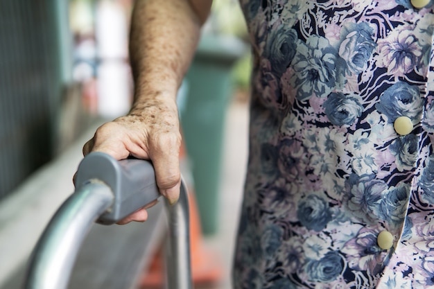 Mano e deambulatore paziente femminile anziano. concetto medico e sanitario.