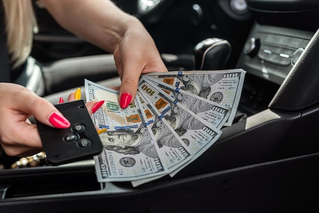 Mano femminile che ci conta dollari in un'auto