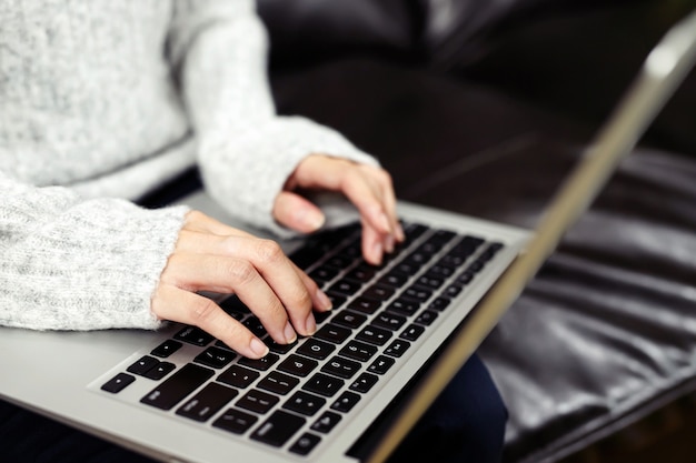 Mano femminile che digita sulla tastiera di un laptop