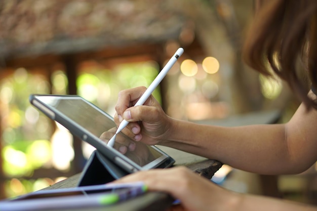 Mano femminile che lavora guardando il piano sul computer nella caffetteria