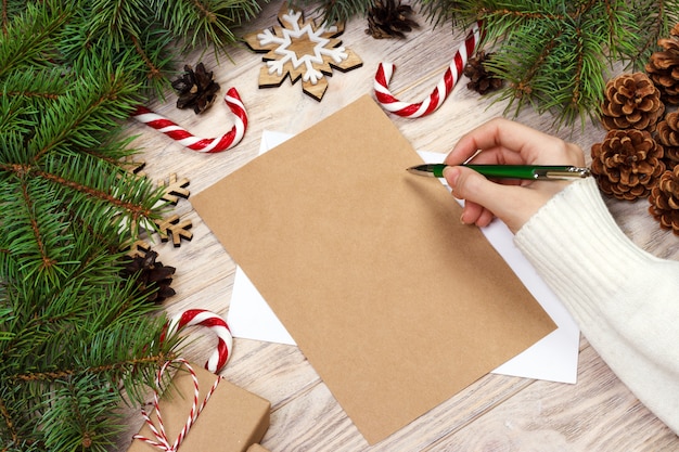 Mano femminile che scrive una lettera di natale