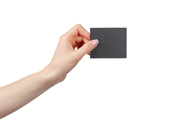 Mano femminile che tiene businesscard nero isolato su sfondo bianco, copia dello spazio