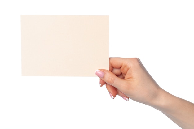 Mano femminile che tiene foglio di carta isolato su sfondo bianco