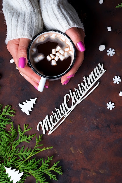 Mano femminile che tiene tazza di cacao caldo