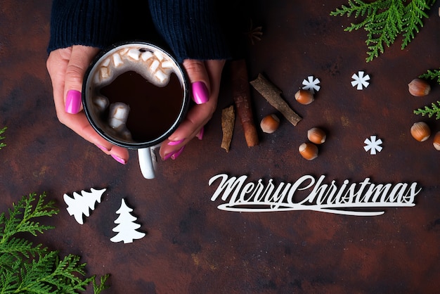 Mano femminile che tiene tazza di cacao caldo