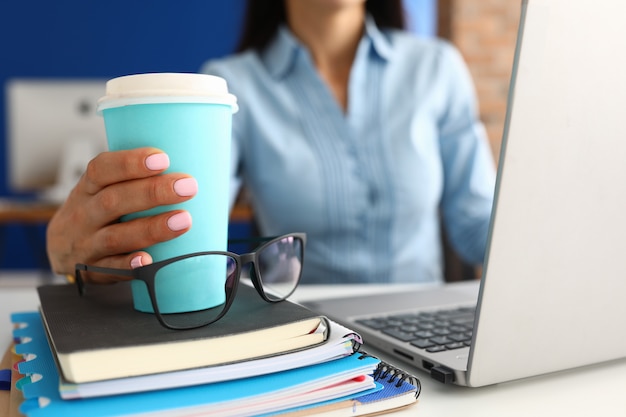 Mano femminile che tiene tazza di caffè blu