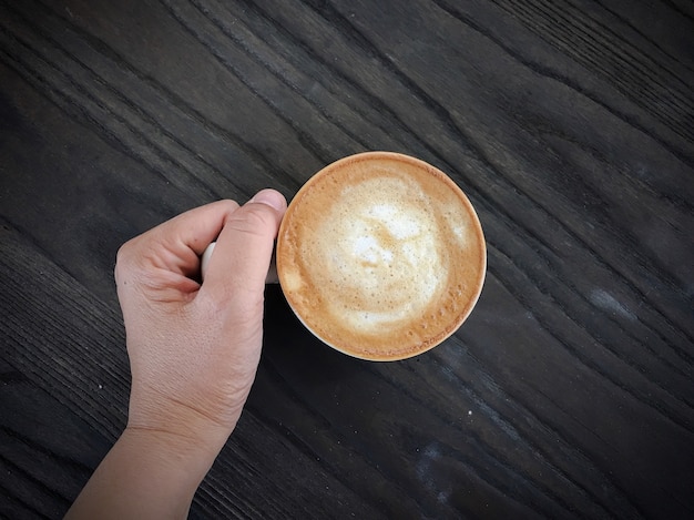 mano femminile che tiene una tazza di caffè