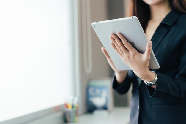 Mano femminile con tavoletta digitale in ufficio