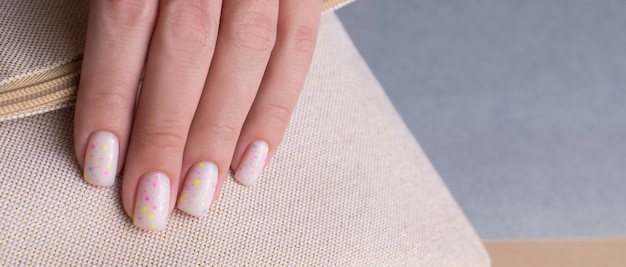 Mano femminile con un bellissimo primo piano manicure bianco. Banner