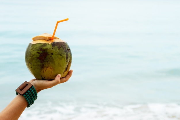 Mano femminile con una noce di cocco