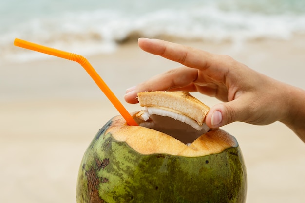 Mano femminile con una noce di cocco