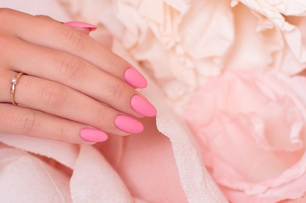 Mano femminile con unghie per manicure da sposa smalto gel rosa