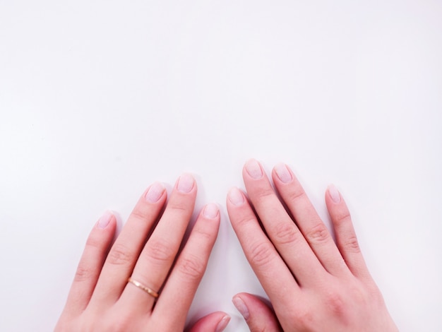 Mano femminile con vista dall'alto manicure ideale. Mani pulite con unghie perfette su sfondo bianco