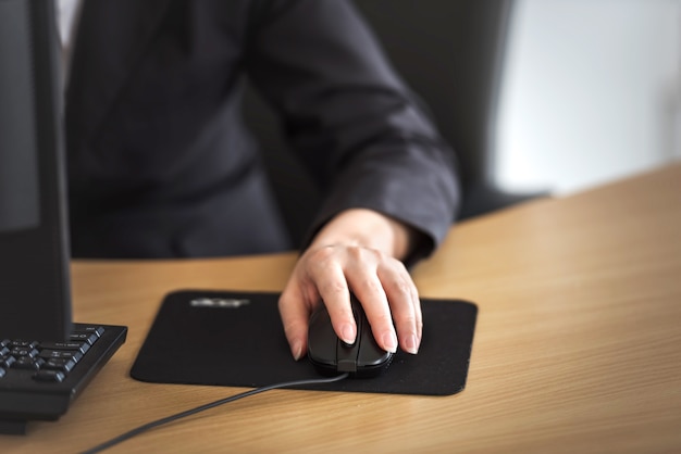 Mano femminile sul mouse del computer