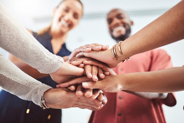 Mano il lavoro di squadra e la motivazione con un team aziendale e le loro mani rannicchiate mentre stanno in cerchio in ufficio insieme Obiettivo di collaborazione e successo con un gruppo di dipendenti in festa