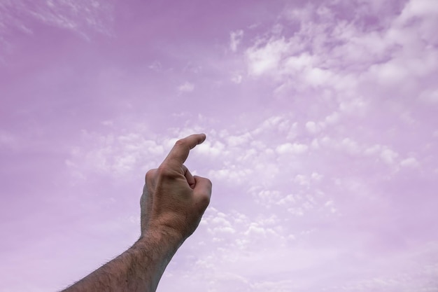 mano in alto gesticolando nei sentimenti e nelle emozioni del cielo rosa