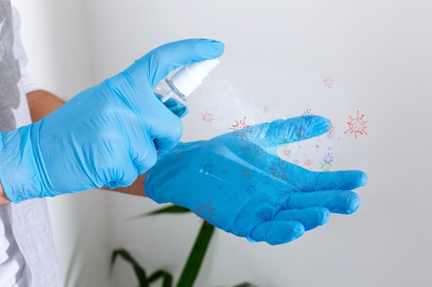 mano in guanti chirurgici di gomma che tengono disinfettante per le mani antisettico sullo sfondo. disinfettanti alcolici o gel per l'igiene delle mani protezione dal virus corona. Liquido antibatterico contro il covid-19