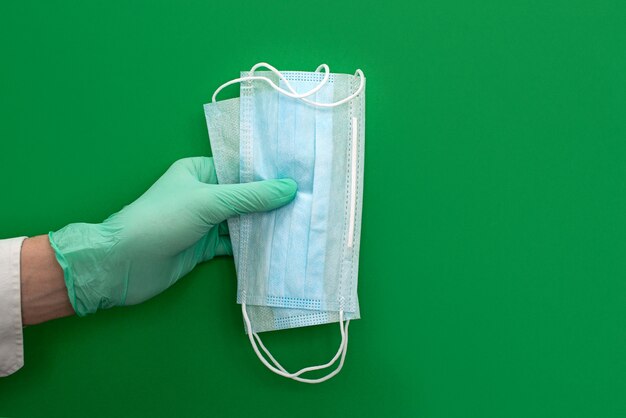 Mano in guanti di protezione medica verde in lattice vaccino antibatterico. Coronavirus concetto di igiene ottimista. Copia spazio