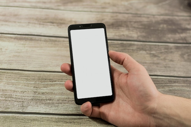 Mano maschile con smartphone con schermo bianco
