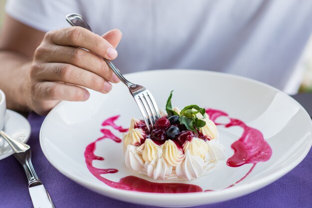 Mano maschile con spina, torta bianca Pavlova