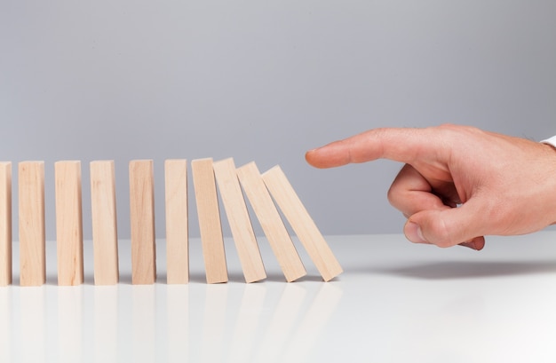 Mano maschile pronta a spingere il domino