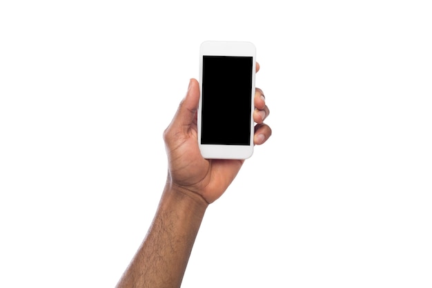 Mano maschio afro-americano che tiene smartphone mobile con schermo vuoto, isolato su sfondo bianco. Copia spazio per la pubblicità dell'app mobile, mockup