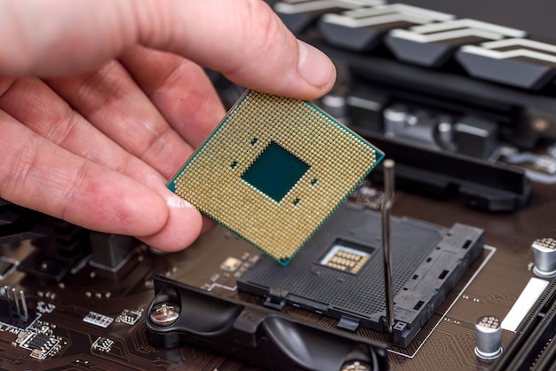 Mano maschio che toglie il chip della CPU dalla scheda madre