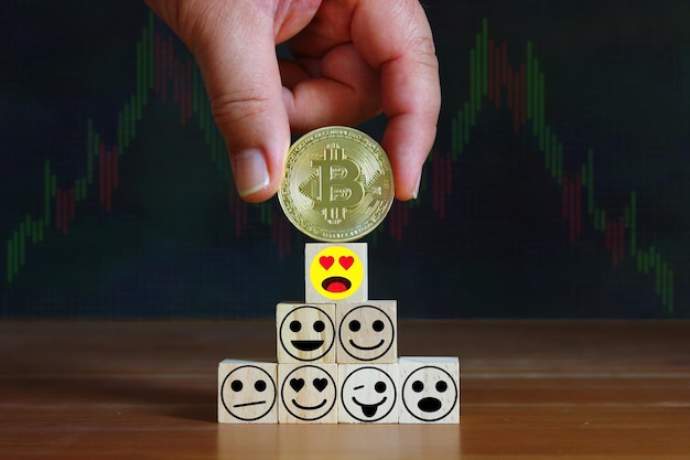 Mano messo su bitcoin sopra il cubo di legno con illustrazione emozione concetto bitcoin