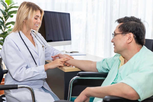 Mano professionale caucasica di medico della donna che tiene l'impulso con il paziente dell'uomo senior alla stanza di ospedale.