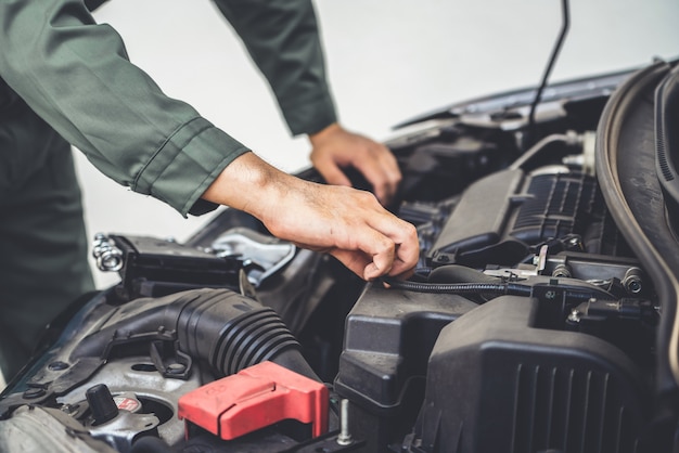 Mano professionale del meccanico che fornisce il servizio di riparazione e manutenzione dell'automobile