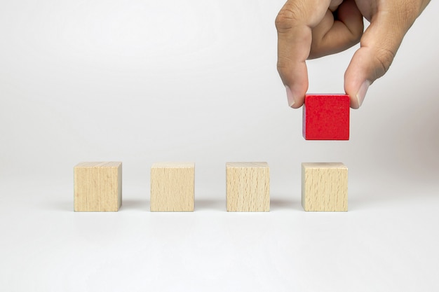 Mano raccolta cubo rosso giocattolo blocco di legno posto in fila senza grafica