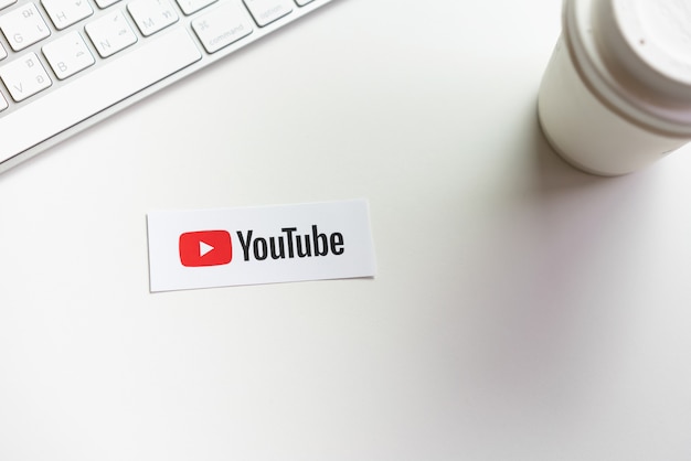 mano sta premendo schermo visualizza le icone delle applicazioni di Youtube su etichetta di carta. YouTube è il famoso sito di condivisione video online.