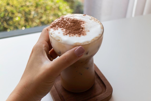 Mano sul bicchiere di caffè freddo